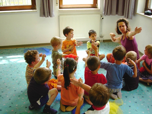 Kinder sitzen im Kreis und musizieren